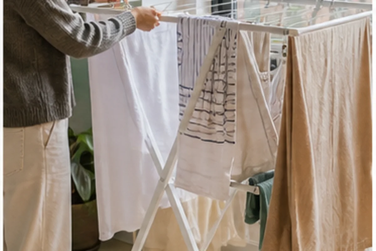 Fresh laundry hanging on a folding rack near an apartment window